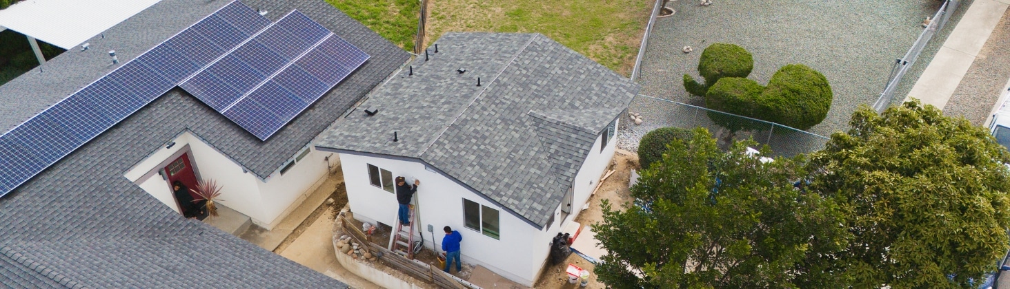 Aerial view of an ADU construction project with solar panels on the main house