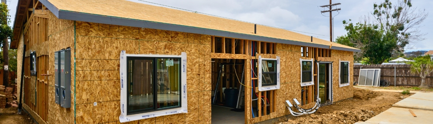 Construction phase of an ADU with visible wooden framing, windows, and electrical systems in progress.